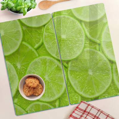 Glass chopping board Lime slices on a green background