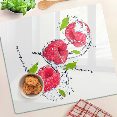Glass chopping board Raspberries in water with leaves