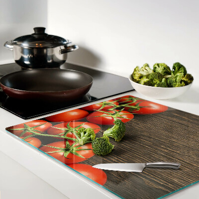 Glass chopping board Tomatoes on a wood background