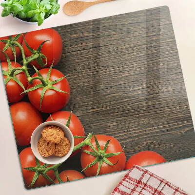 Glass chopping board Tomatoes on a wood background