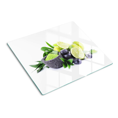 Glass chopping board Lemons and grapes on a green background