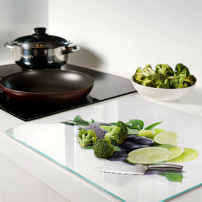 Glass chopping board Lemons and grapes on a green background