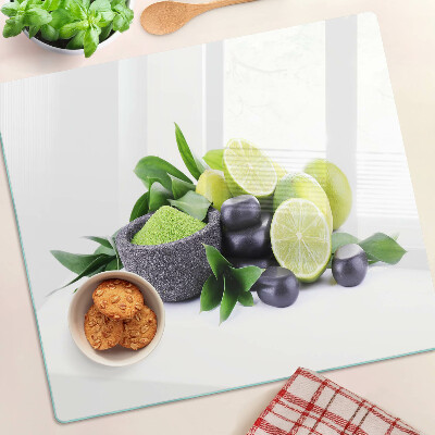 Glass chopping board Lemons and grapes on a green background