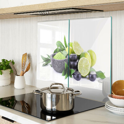 Glass chopping board Lemons and grapes on a green background