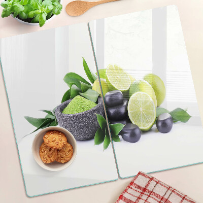 Glass chopping board Lemons and grapes on a green background