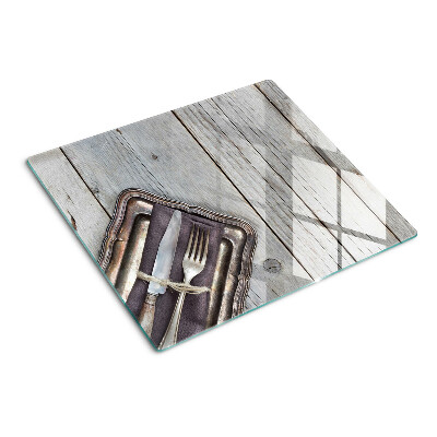 Glass chopping board Rustic cutlery on a wooden background