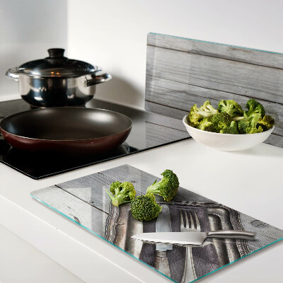 Glass chopping board Rustic cutlery on a wooden background