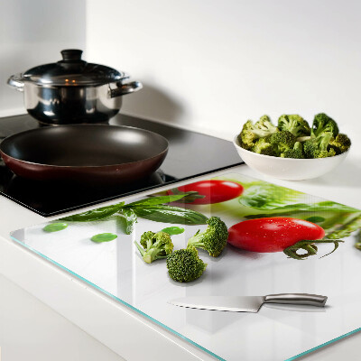 Glass chopping board Vegetables on a white countertop