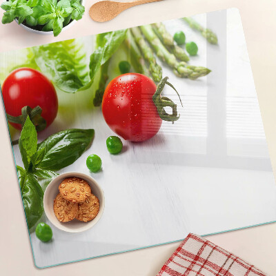 Glass chopping board Vegetables on a white countertop