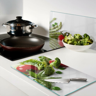 Glass chopping board Vegetables on a white countertop