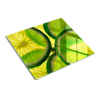 Glass kitchen board Lime slices on a green background