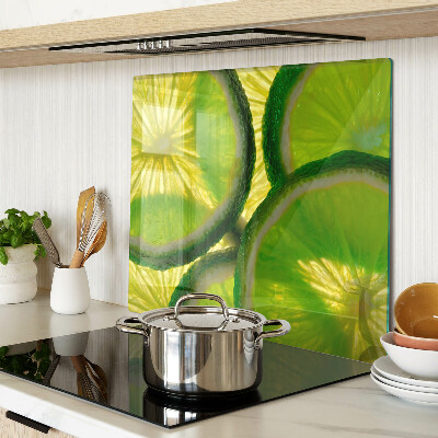Glass kitchen board Lime slices on a green background
