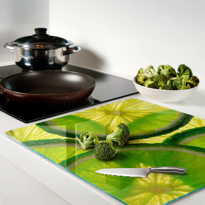 Glass kitchen board Lime slices on a green background