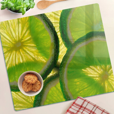 Glass kitchen board Lime slices on a green background