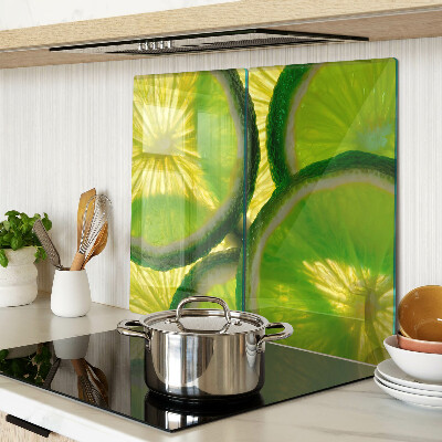 Glass kitchen board Lime slices on a green background