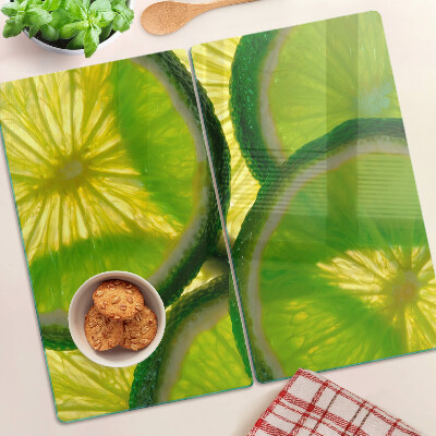 Glass kitchen board Lime slices on a green background
