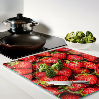 Glass chopping board Strawberries on a red background