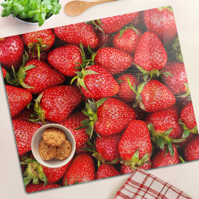 Glass chopping board Strawberries on a red background