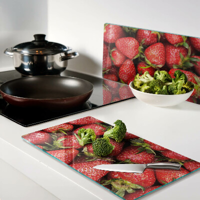 Glass chopping board Strawberries on a red background