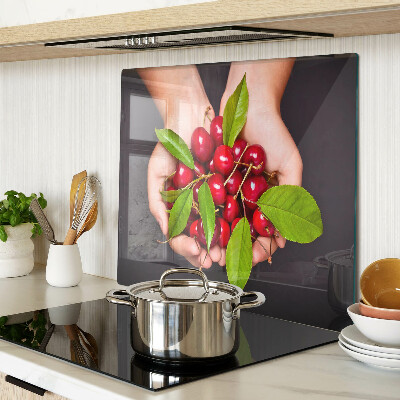 Glass chopping board Red cherries in hands