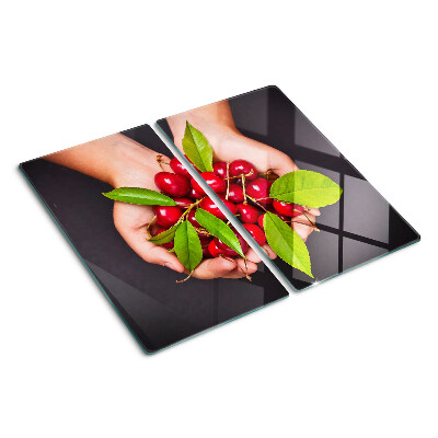 Glass chopping board Red cherries in hands