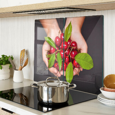 Glass chopping board Red cherries in hands