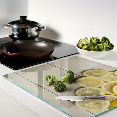 Glass chopping board Lemon slices on a wooden background