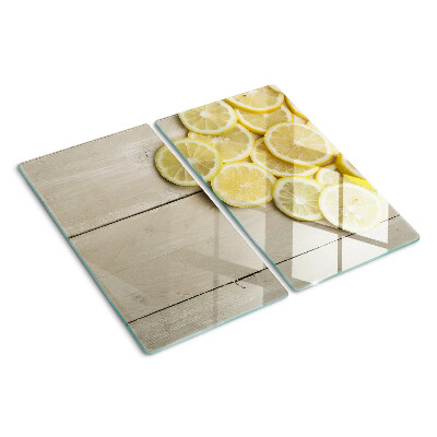 Glass chopping board Lemon slices on a wooden background