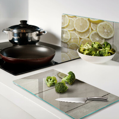 Glass chopping board Lemon slices on a wooden background