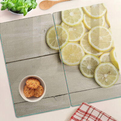 Glass chopping board Lemon slices on a wooden background