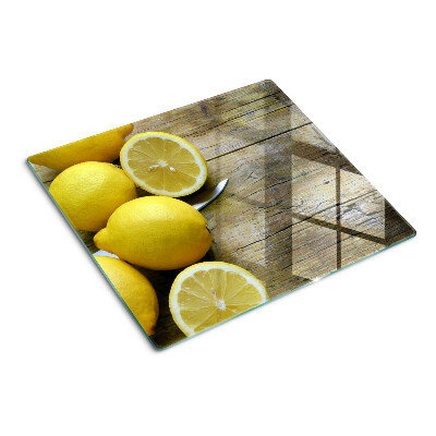 Glass chopping board Lemons on a wooden background