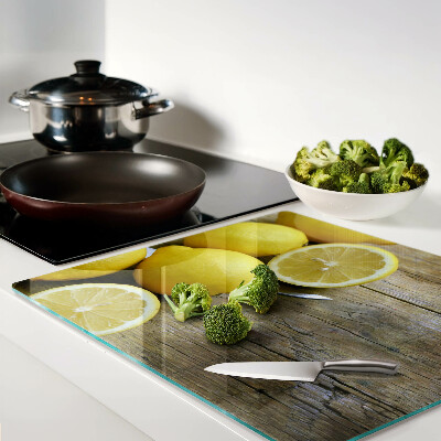 Glass chopping board Lemons on a wooden background