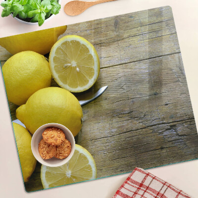 Glass chopping board Lemons on a wooden background