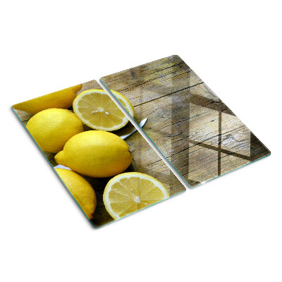 Glass chopping board Lemons on a wooden background