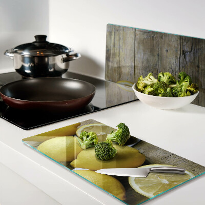 Glass chopping board Lemons on a wooden background