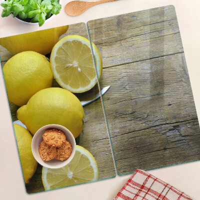 Glass chopping board Lemons on a wooden background