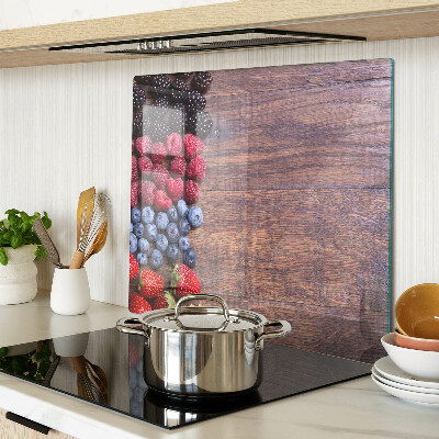 Glass chopping board Forest fruits on a wooden background