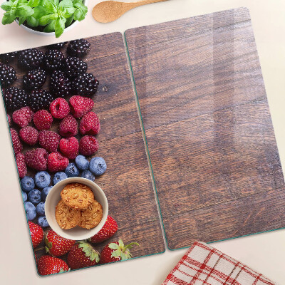 Glass chopping board Forest fruits on a wooden background