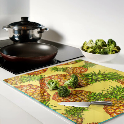 Glass kitchen board Pineapples on a yellow background