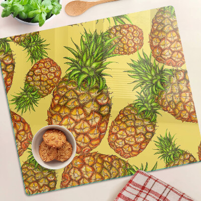 Glass kitchen board Pineapples on a yellow background