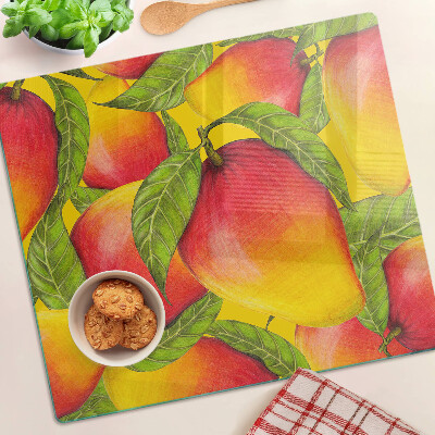 Glass chopping board Peppers on a background of green leaves