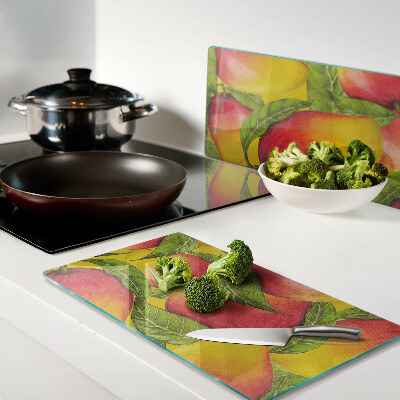 Glass chopping board Peppers on a background of green leaves