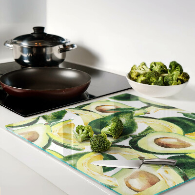 Glass kitchen board Avocado on a background of leaves