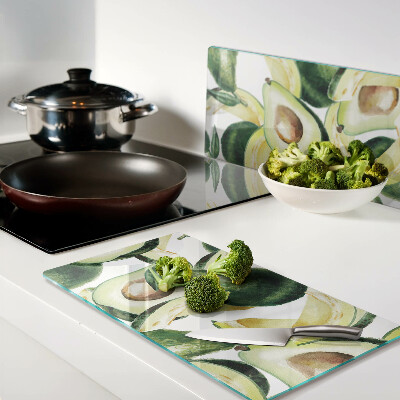 Glass kitchen board Avocado on a background of leaves