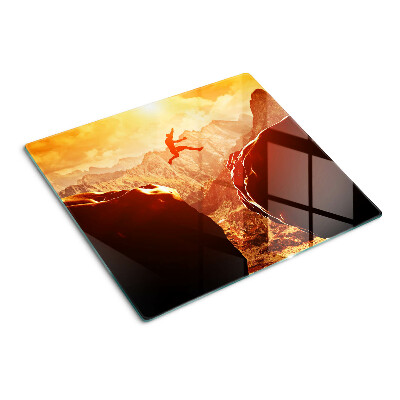 Glass kitchen board Jumping in the mountains at sunset