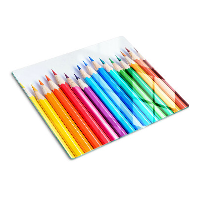 Glass chopping board Colored pencils in a row
