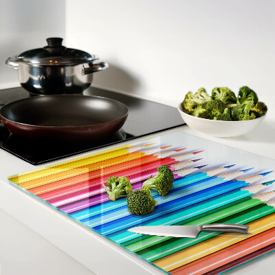 Glass chopping board Colored pencils in a row