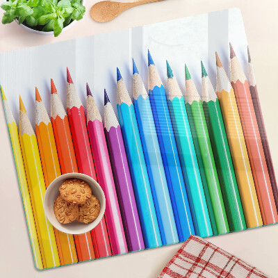 Glass chopping board Colored pencils in a row