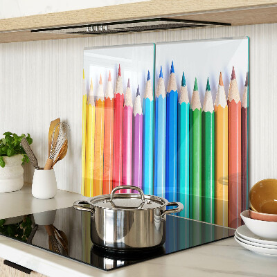 Glass chopping board Colored pencils in a row