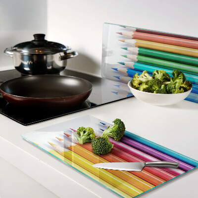 Glass chopping board Colored pencils in a row